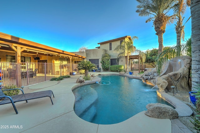 view of pool with pool water feature, a pergola, and a patio area