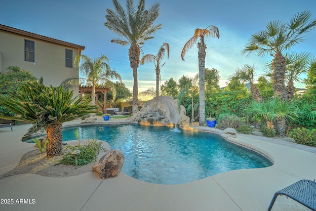 pool at dusk with a pergola, a patio area, and a water slide