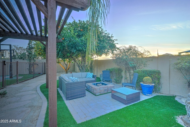 patio terrace at dusk with an outdoor living space with a fire pit