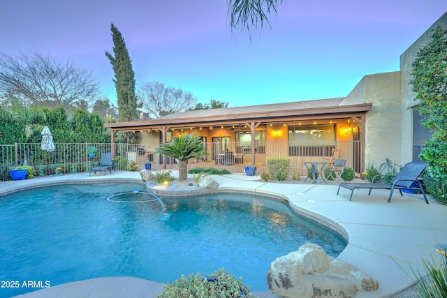 pool at dusk featuring a patio area