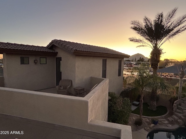 property exterior at dusk featuring a patio area