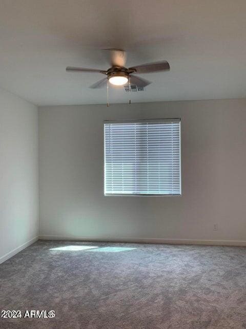 carpeted spare room with ceiling fan