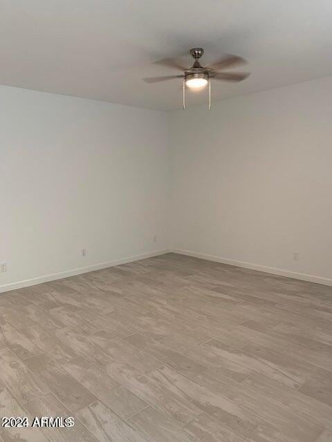 empty room featuring ceiling fan and light hardwood / wood-style flooring