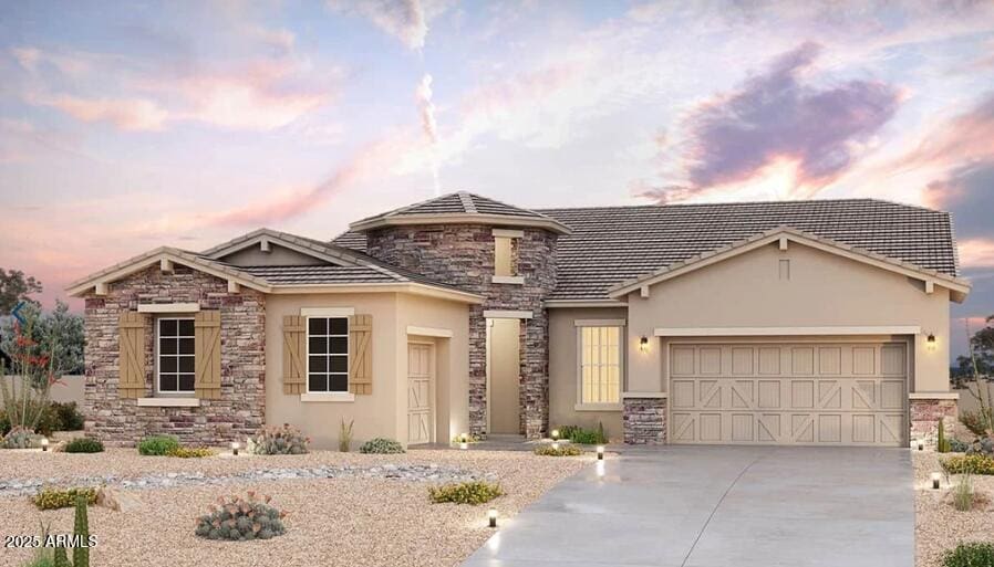 view of front of house featuring a garage, driveway, stone siding, and stucco siding