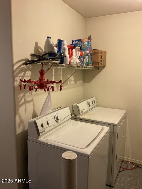 washroom with independent washer and dryer and baseboards