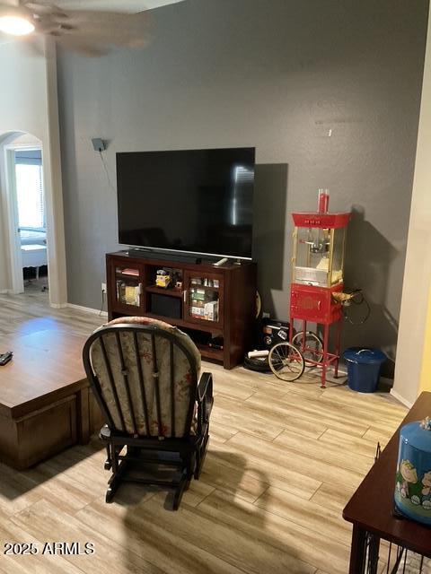 living room featuring arched walkways and wood finished floors