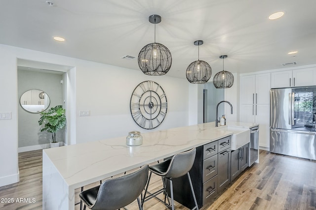 kitchen featuring stainless steel appliances, a chandelier, a sink, and visible vents