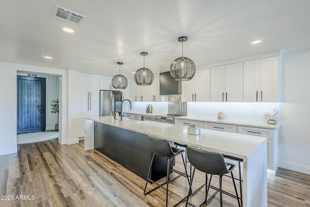 kitchen with visible vents, baseboards, white cabinetry, backsplash, and stainless steel appliances