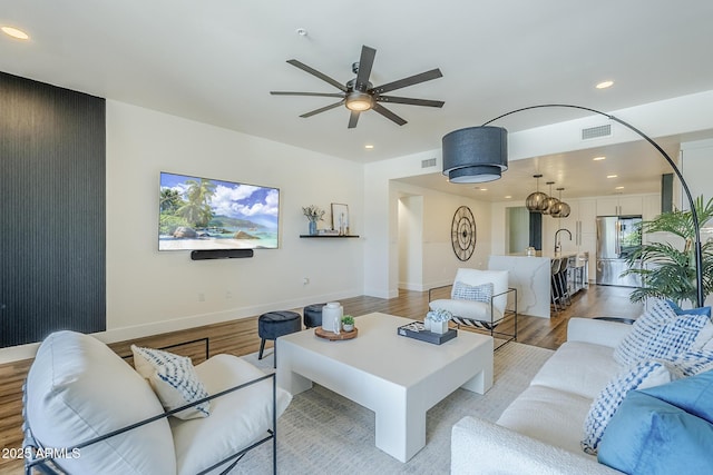 living area featuring ceiling fan, recessed lighting, baseboards, light wood-type flooring, and visible vents