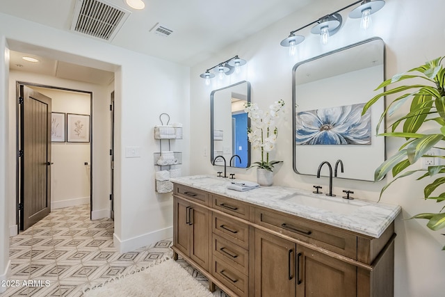 bathroom with visible vents, a sink, baseboards, and double vanity