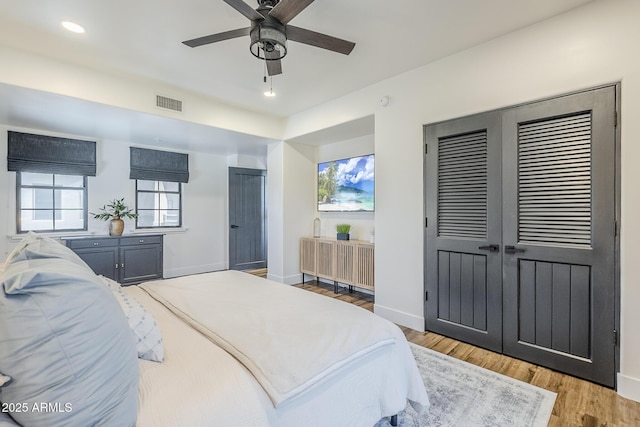 bedroom featuring a ceiling fan, visible vents, baseboards, light wood-style floors, and recessed lighting