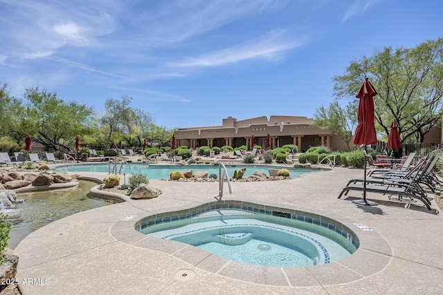 pool with a hot tub and a patio area