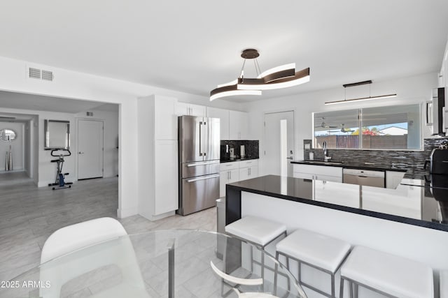 3758 E Sunnyside Dr, Phoenix, AZ 85028 - kitchen with dark countertops, visible vents, a sink, decorative backsplash, and appliances with stainless steel finishes