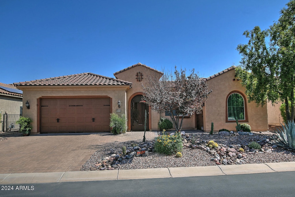 mediterranean / spanish-style home with a garage