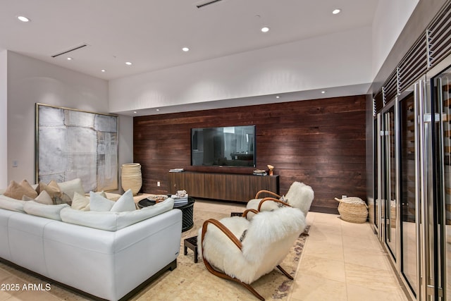 living room featuring light tile patterned floors and wooden walls