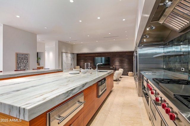 kitchen featuring stainless steel stove, sink, light stone countertops, and light tile patterned floors