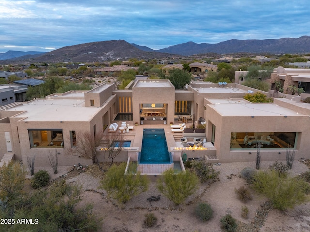 rear view of house featuring a mountain view, a patio area, and a fire pit