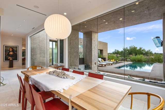 tiled dining space featuring a high ceiling and a wall of windows