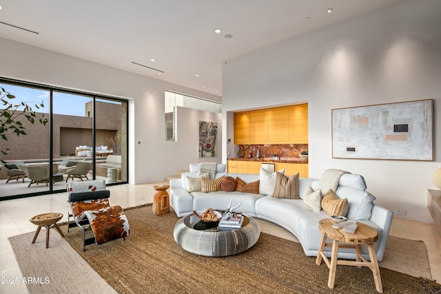 living room with light tile patterned flooring and a towering ceiling