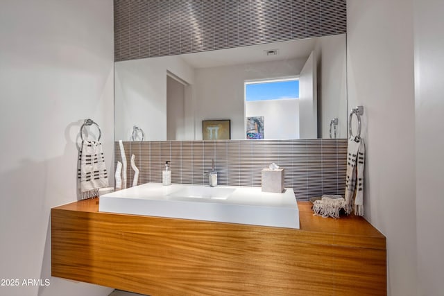 bathroom featuring vanity and decorative backsplash