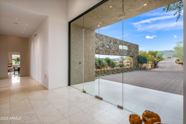 interior space with tile patterned flooring, a mountain view, and a towering ceiling