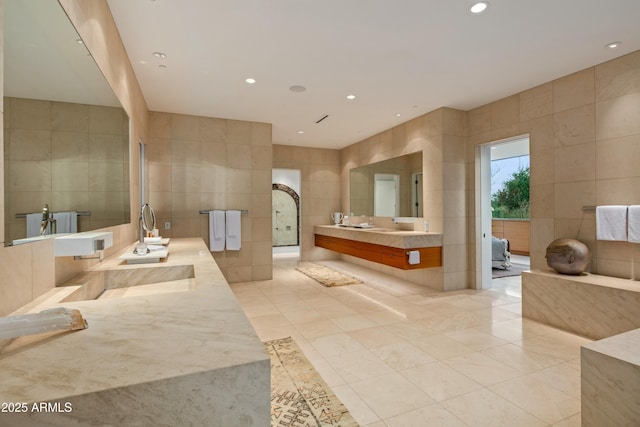 bathroom featuring vanity, tile patterned flooring, and tile walls