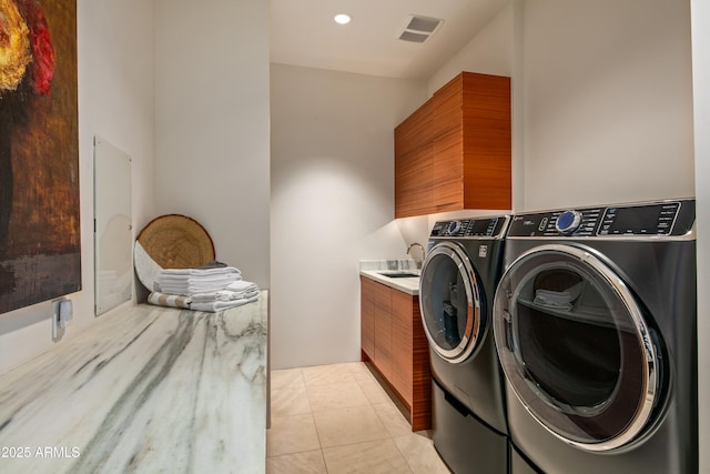 laundry area featuring washer and dryer, sink, cabinets, and light tile patterned flooring