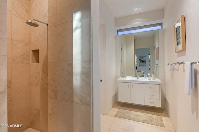 bathroom featuring tiled shower, vanity, and tile patterned flooring