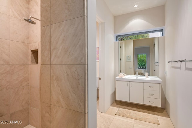 bathroom featuring tile patterned floors, vanity, and a tile shower