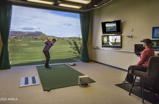 recreation room with golf simulator, a mountain view, and carpet