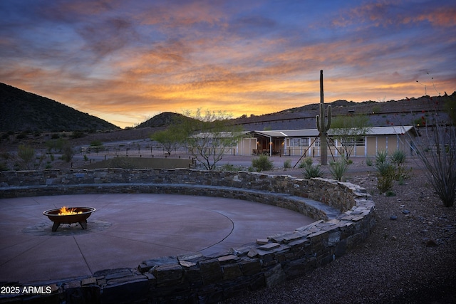 exterior space with a mountain view and an outdoor fire pit