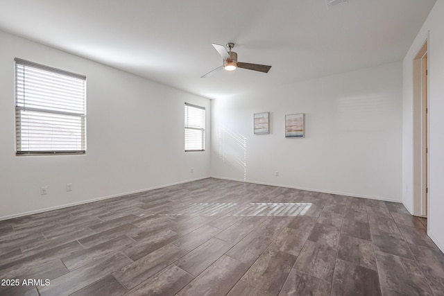 empty room with ceiling fan and dark hardwood / wood-style flooring