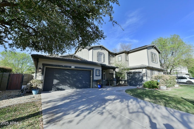 traditional home featuring concrete driveway, fence, and an attached garage