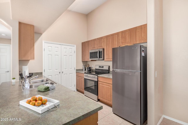 kitchen featuring high vaulted ceiling, stainless steel appliances, sink, and light tile patterned floors