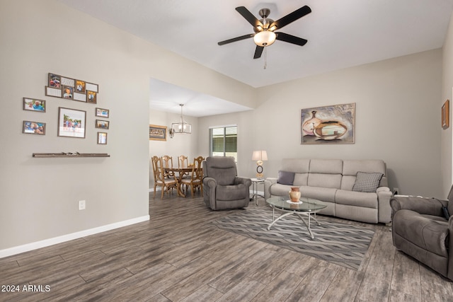 living room with ceiling fan with notable chandelier and dark wood-type flooring