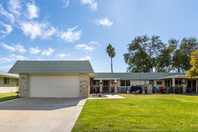 ranch-style house featuring a front lawn and a garage