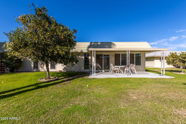 rear view of house featuring a patio area and a yard