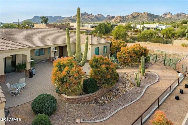 view of front of property featuring a mountain view and a patio