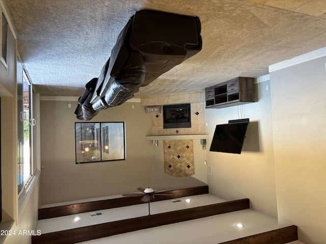 stairs featuring a textured ceiling and ceiling fan