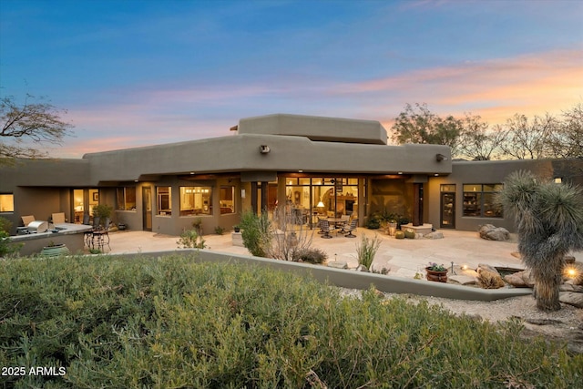 back house at dusk with a patio