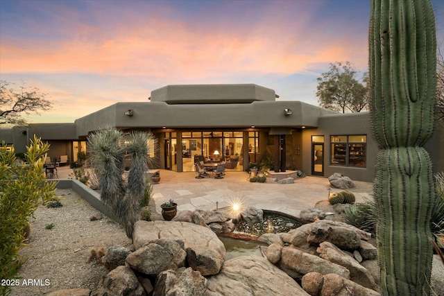 back house at dusk with a patio