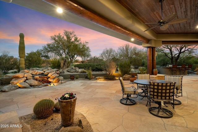 patio terrace at dusk with a bar and ceiling fan