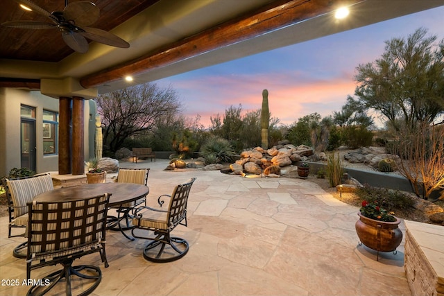 patio terrace at dusk featuring ceiling fan