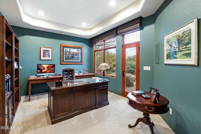 carpeted office with a tray ceiling