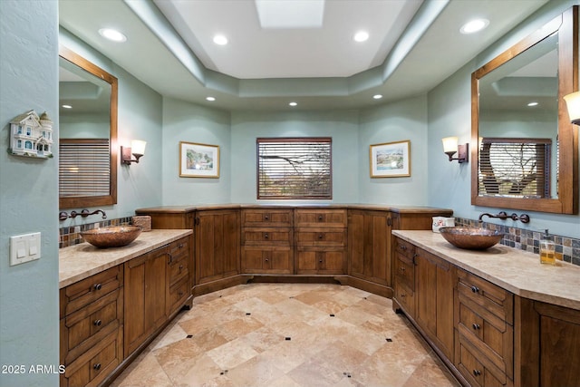 bathroom featuring vanity, backsplash, and a tray ceiling