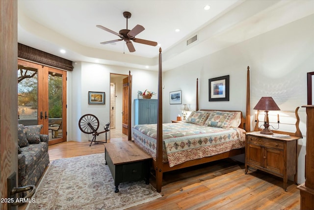 bedroom with light wood-type flooring, ceiling fan, and french doors