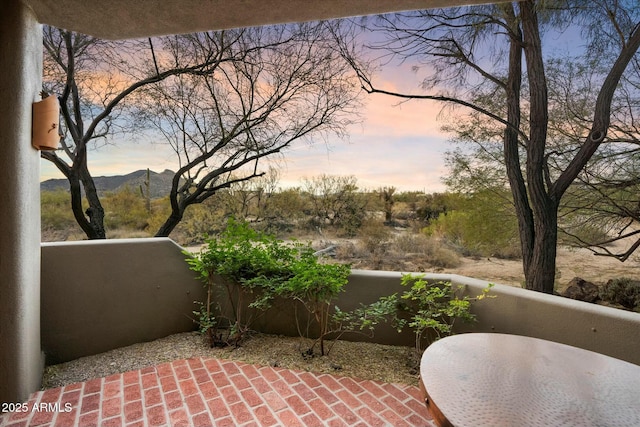 patio terrace at dusk featuring a mountain view