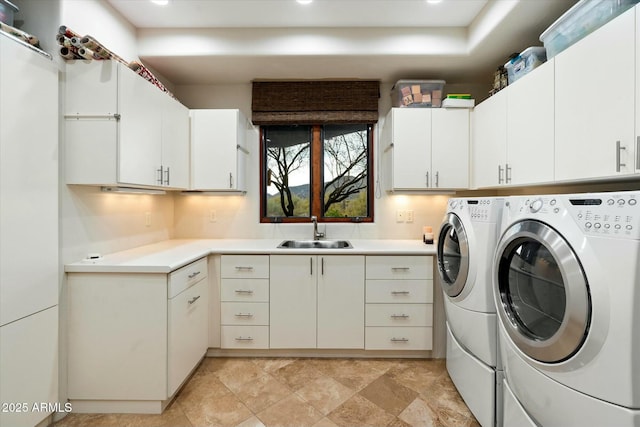 laundry room featuring cabinets, sink, and washer and dryer