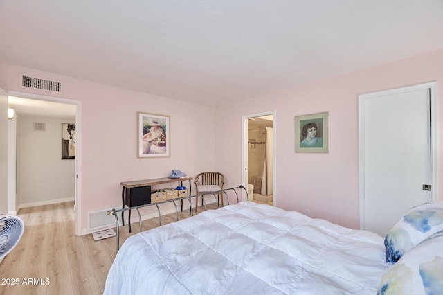bedroom featuring baseboards, light wood-type flooring, and visible vents