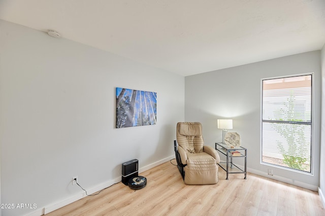 living area with wood finished floors, plenty of natural light, and baseboards